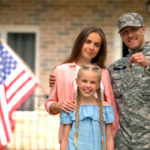 Family and veteran in front of home.