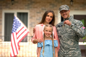 Family and veteran in front of home.